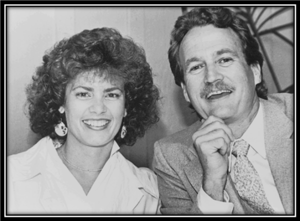 Smiling man and woman in formal attire.