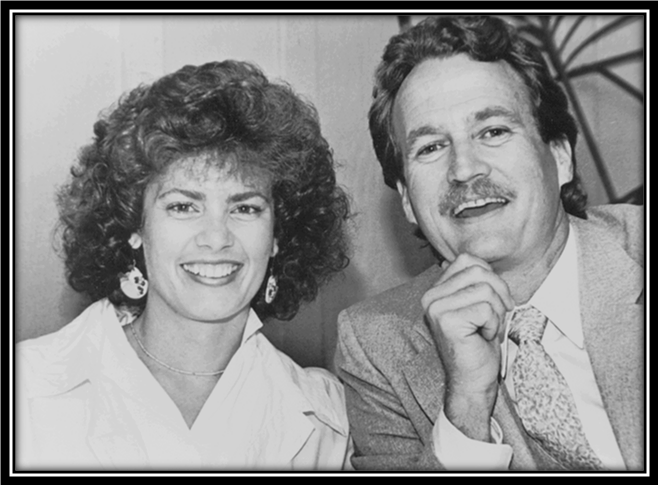 Smiling man and woman in formal attire.